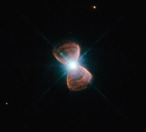 这幅图显示了仙后座星群中的一个双极行星状星云——PN Hb 12，更流行的叫法是哈勃12。这个星云的形状引人注目，让人联想到一只蝴蝶或一个沙漏，它的形成是由于一个类似太阳的恒星在接近其寿命结束时将它的外层大气抛至周围空间。