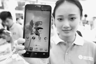 在中国移动4G手机全国首发仪式上，工作人员在展示一款4G手机。 　　新华社发